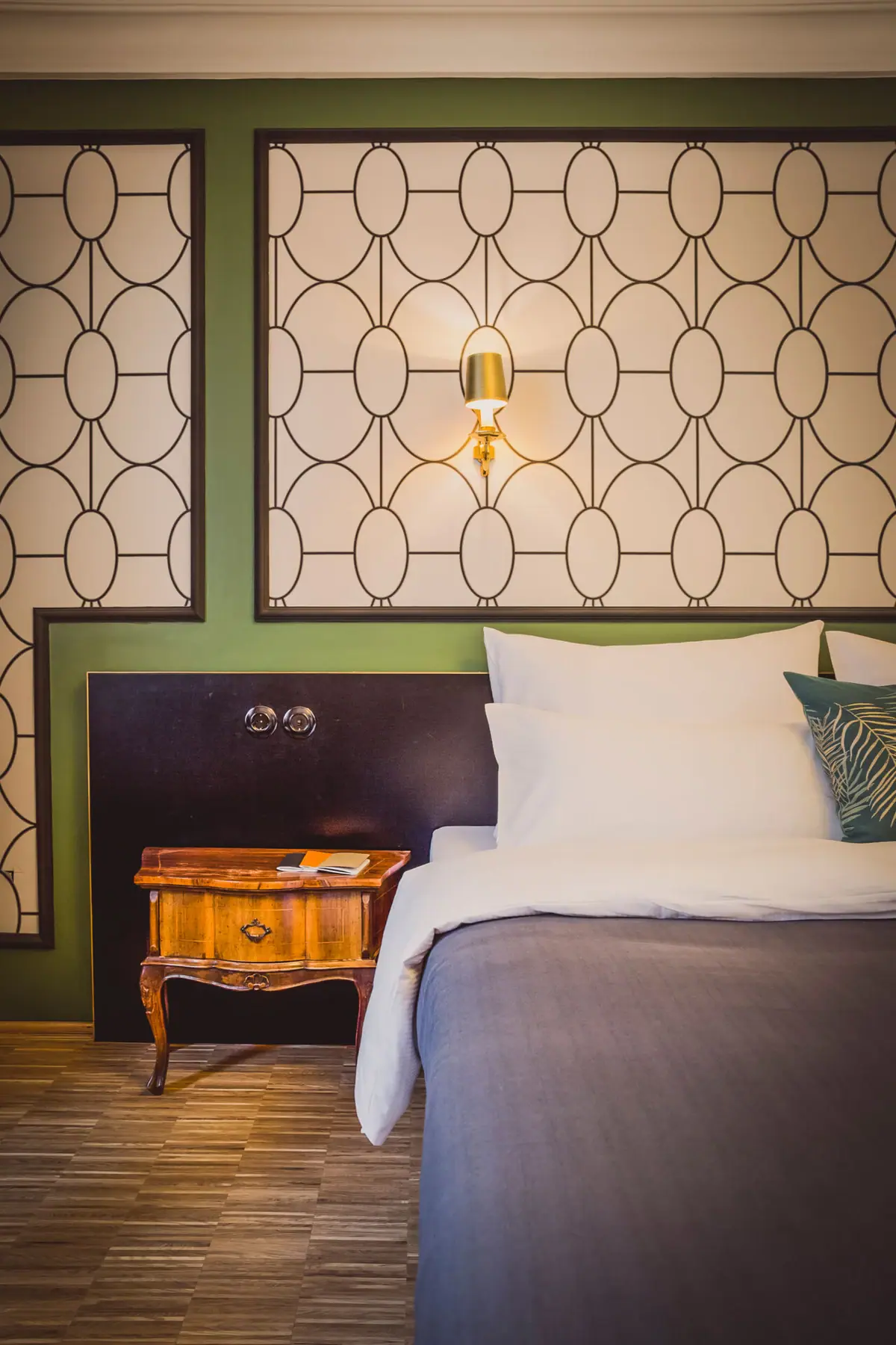 A bed with pillows and a bedside table.