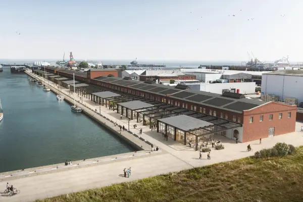 A dock with a building and a body of water outside.